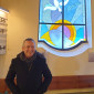 Landesbischof vor einem bunten Glasfenster in der Markuskirche Lam
